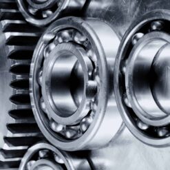 Close-up view of metal ball bearings and gear cogs, their shiny surfaces enhanced by discontinued Teflon™ Severe Service Grease for smooth, reliable machinery operation.