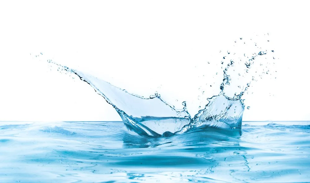 A splash of water creating droplets in a clear blue water surface.